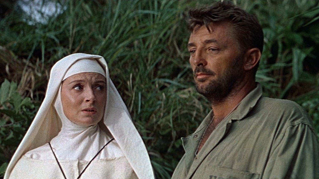 Still from Heaven Knows, Mr. Allison. Deborah Kerr watches Robert Mitchum, standing in front of the trees on an isolated Pacific island.