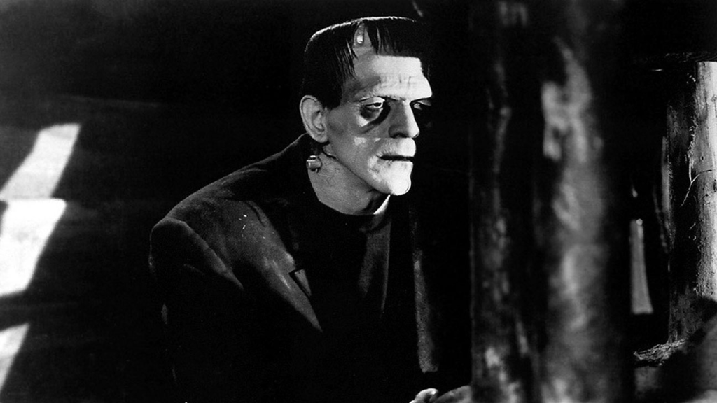 Frankenstein watches from the shadows.