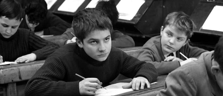 Antoine Doinel glares at the teacher from his school desk.