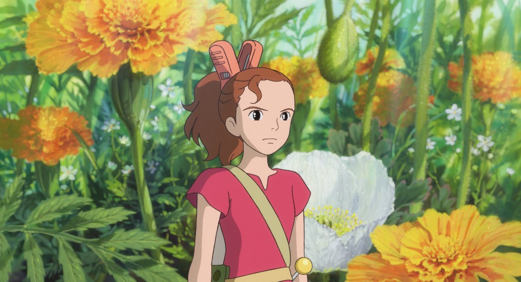 From The Secret World of Arrietty. Tiny Arriety looks ahead with a determined face, standing in front of a patch of yellow and white flowers.